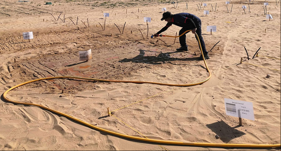 A man spraying clay onto the ground before planting any plants